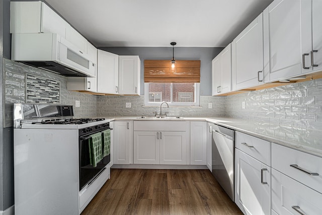 kitchen with a sink, white appliances, white cabinetry, decorative backsplash, and dark wood-style floors