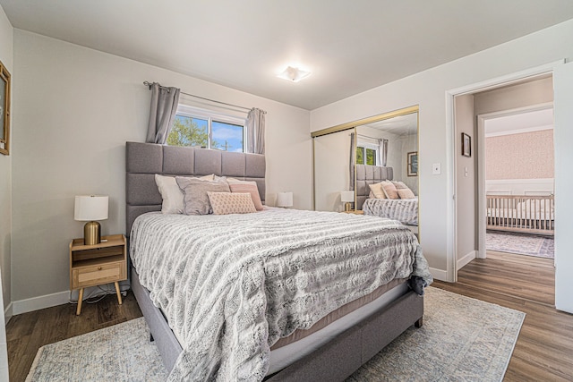 bedroom with baseboards, a closet, and dark wood finished floors