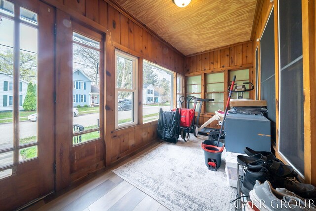 sunroom featuring plenty of natural light, wood walls, wood ceiling, and wood finished floors