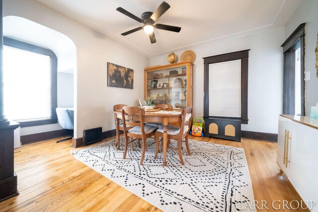 dining area featuring wood finished floors, a ceiling fan, and baseboards