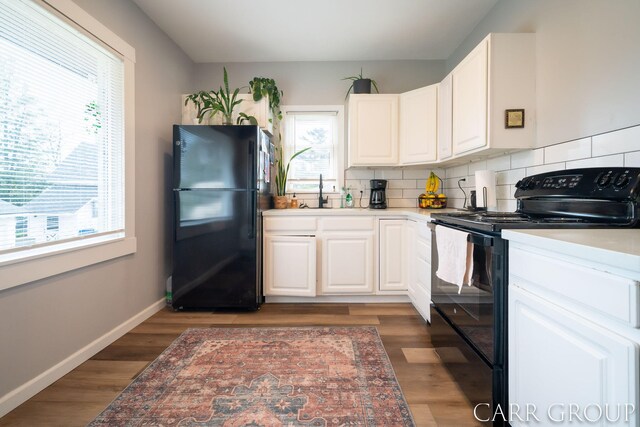 kitchen featuring black appliances, a healthy amount of sunlight, and white cabinetry