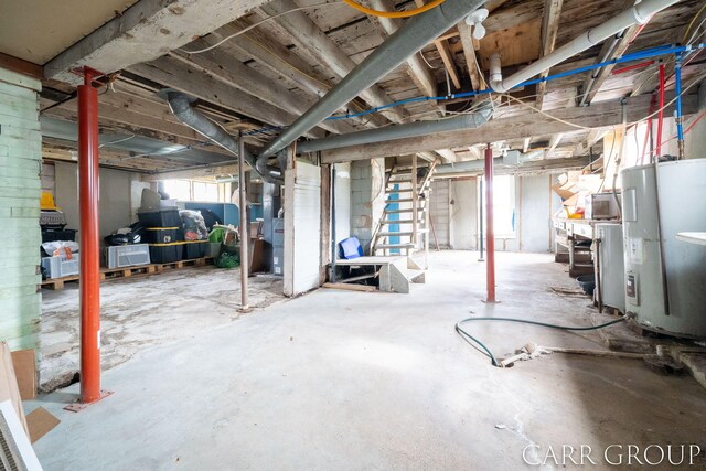 basement with electric water heater and stairway