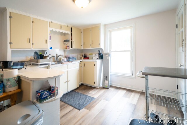 kitchen featuring open shelves, light countertops, plenty of natural light, and cream cabinetry