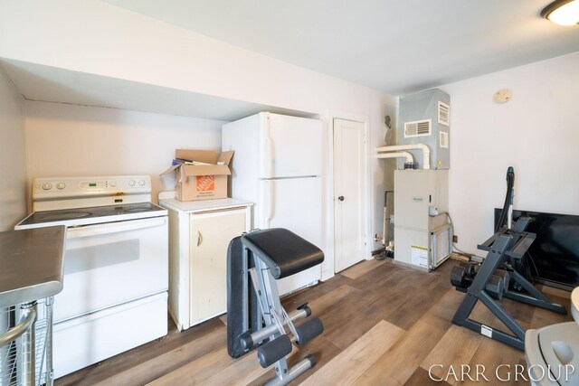 kitchen featuring light countertops, wood finished floors, visible vents, and white appliances