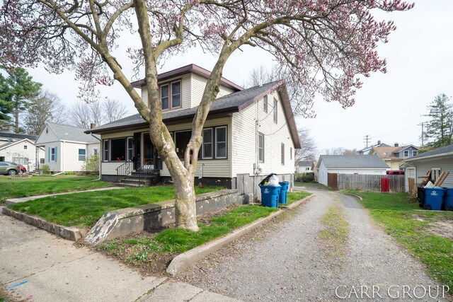 bungalow-style house with gravel driveway, a front lawn, and fence