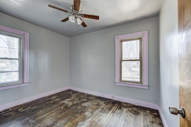 spare room with a healthy amount of sunlight, dark wood-type flooring, and visible vents