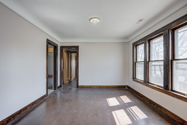 unfurnished room with visible vents and baseboards