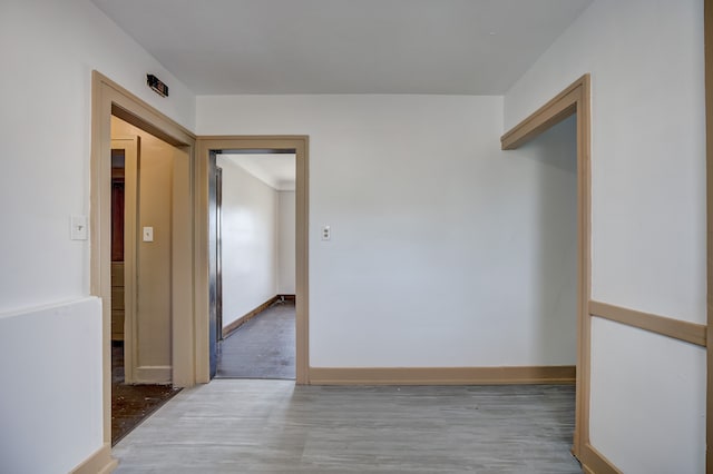 hall featuring baseboards and wood finished floors
