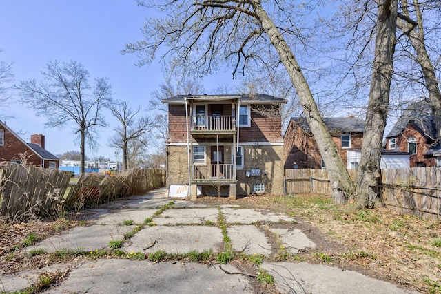 rear view of property featuring fence private yard and a balcony