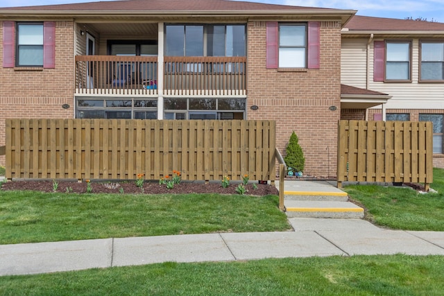 view of front of house featuring fence and brick siding