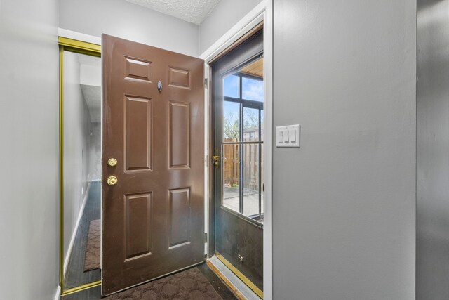doorway with a textured ceiling