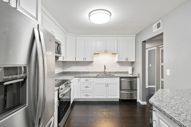 kitchen with dark wood-style flooring, visible vents, a sink, white cabinets, and stainless steel appliances