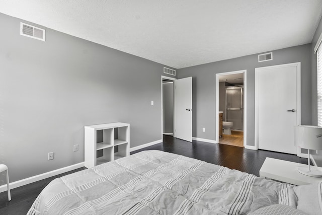 bedroom with baseboards, visible vents, and wood finished floors
