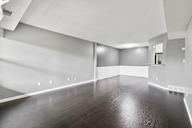 interior space featuring a textured ceiling, visible vents, and wood finished floors