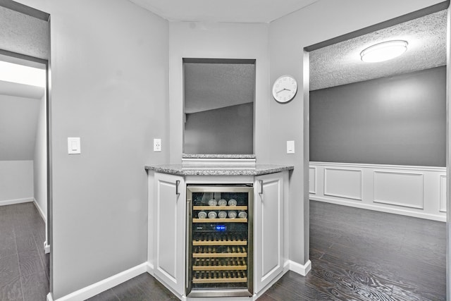 bar featuring wainscoting, wine cooler, and dark wood-style floors