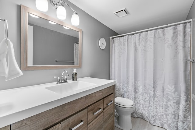bathroom with vanity, toilet, and visible vents