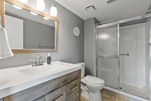 bathroom with visible vents, vanity, toilet, and a shower stall
