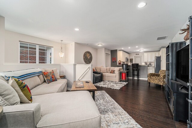 living area featuring recessed lighting, dark wood-style flooring, and visible vents