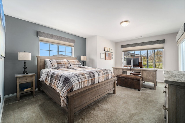 carpeted bedroom featuring baseboards, visible vents, and multiple windows