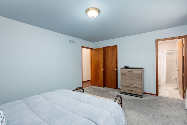bedroom featuring baseboards, visible vents, light colored carpet, a closet, and connected bathroom