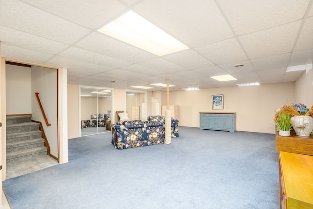 interior space with a paneled ceiling, carpet flooring, and stairs