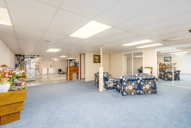carpeted living area featuring a paneled ceiling