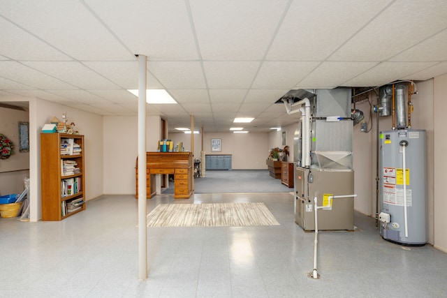 finished below grade area with tile patterned floors, heating unit, gas water heater, and a paneled ceiling
