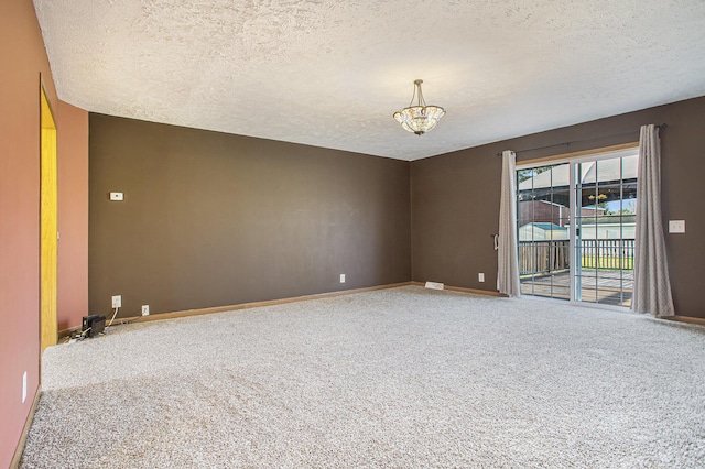 17026 H Dr S, Marshall, MI 49068 - empty room with baseboards, an inviting chandelier, a textured ceiling, and carpet
