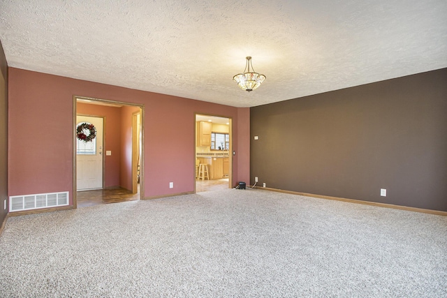 17026 H Dr S, Marshall, MI 49068 - carpeted spare room featuring baseboards, visible vents, a textured ceiling, and a chandelier