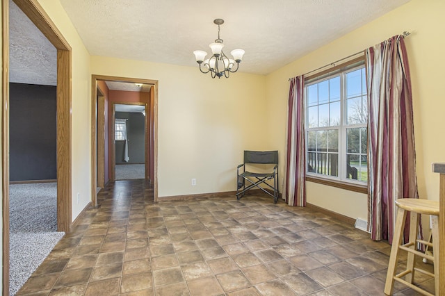 17026 H Dr S, Marshall, MI 49068 - interior space with stone finish floor, baseboards, a textured ceiling, and a chandelier