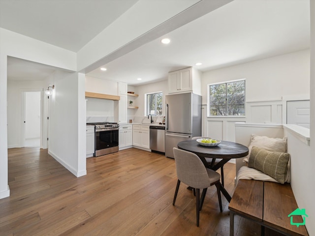 dining space with light wood finished floors and recessed lighting