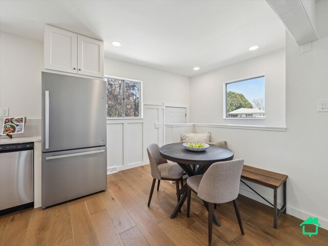 dining room featuring light wood-type flooring, recessed lighting, and plenty of natural light