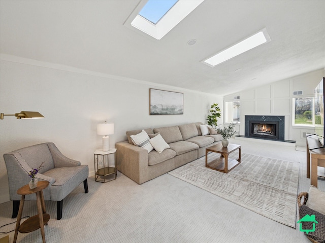 carpeted living room featuring visible vents, a high end fireplace, and lofted ceiling with skylight
