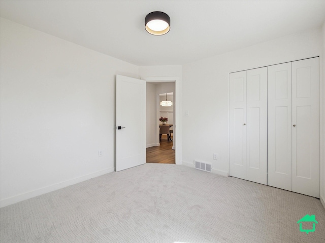 unfurnished bedroom featuring visible vents, a closet, baseboards, and carpet floors