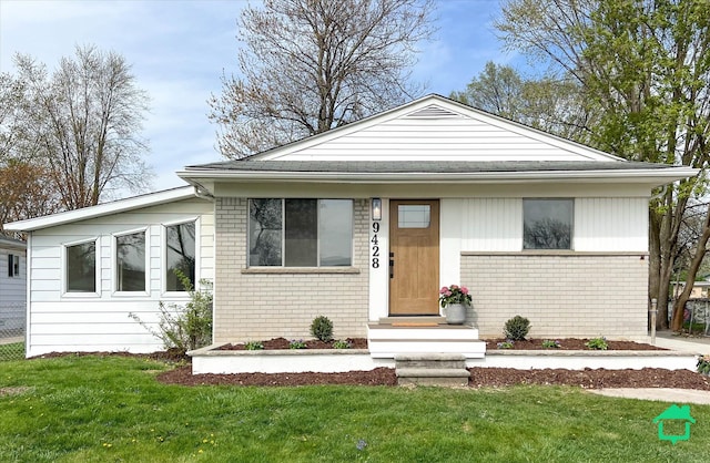 view of front of house with a front yard and brick siding