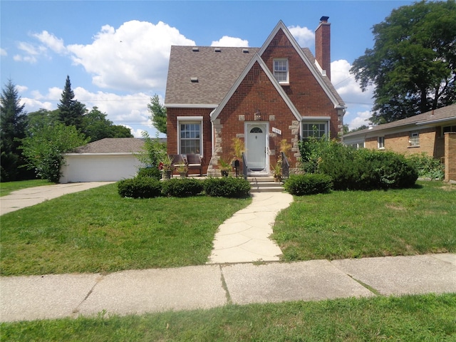 1353 N Gulley Rd, Dearborn Heights, MI 48127 - tudor house featuring a chimney, brick siding, a front yard, and roof with shingles