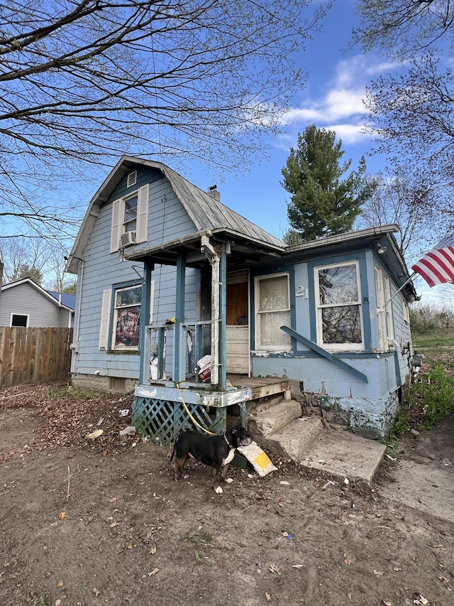 view of front of home with cooling unit and fence