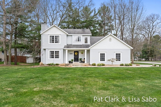15346 Nickolas Dr, Grand Haven, MI 49417 - traditional home with a front lawn, a chimney, roof with shingles, and covered porch