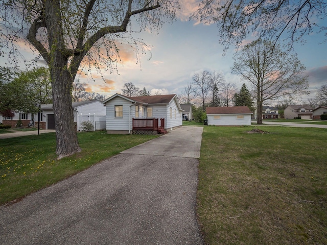 bungalow-style home with a yard and concrete driveway