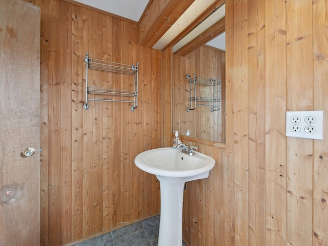 bathroom featuring wood walls and a sink