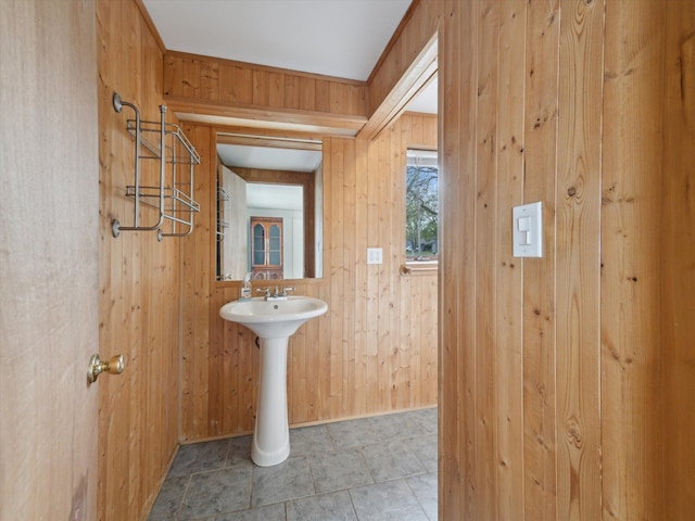 half bathroom with a sink and wooden walls