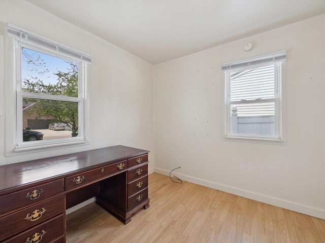home office with ornamental molding, light wood-style flooring, and a healthy amount of sunlight