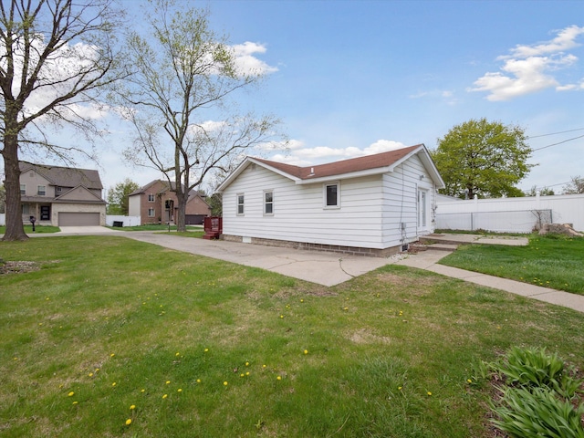view of side of property featuring fence and a yard