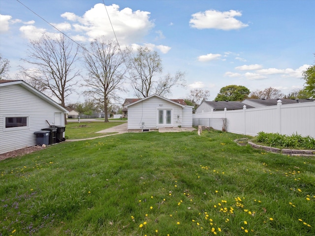 view of yard with a patio area, fence, and french doors