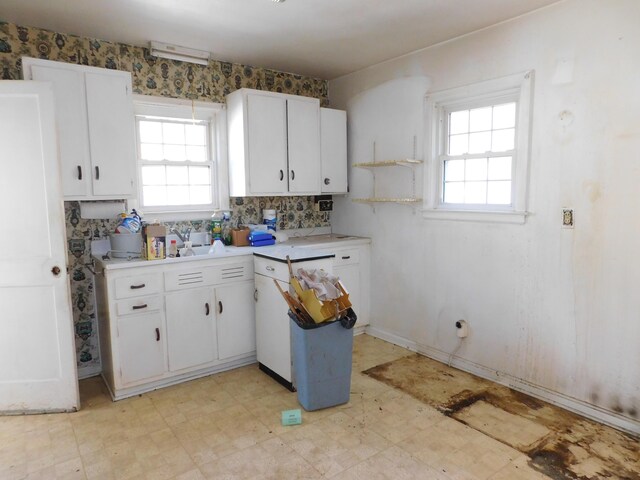 kitchen featuring light floors, backsplash, white cabinetry, and light countertops