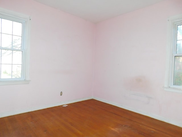 spare room with wood finished floors and baseboards