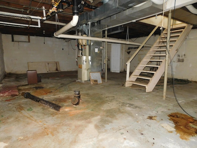 unfinished basement featuring stairs and heating unit