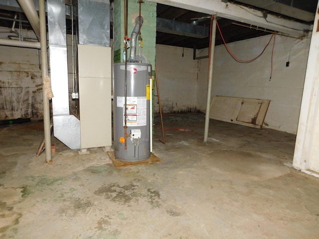 unfinished below grade area featuring concrete block wall, heating unit, and gas water heater