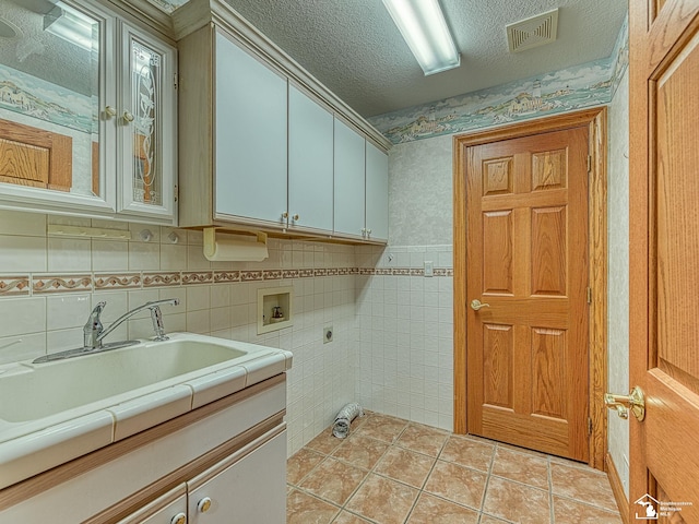 3158 Lennox Ct, Lambertville, MI 48144 - washroom featuring cabinet space, electric dryer hookup, hookup for a washing machine, a textured ceiling, and light tile patterned flooring