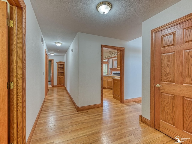 3158 Lennox Ct, Lambertville, MI 48144 - hallway with a textured ceiling, light wood-style floors, and baseboards